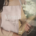Tablier L'amour de maman et ses câlins rose | Cadeau de la<br><div class="desc">Laissez Maman cuisiner, cuire ou griller avec style avec ce tablier rose "Maman's Love & Hugs" ! Conçu avec amour, ce tablier charmant et pratique est parfait pour les mamans qui apportent chaleur et joie à la cuisine. Le design rose pastel doux ajoute une touche douce et élégante, ce qui...</div>