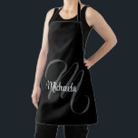Tablier Nom initial de monogramme moderne minimaliste<br><div class="desc">Monogramme moderne minimaliste nom initial noir blanc. Nom personnalisé personnalisable avec une initiale cursive derrière sur une couleur noire.</div>