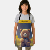 Tablier ours en peluche dans une prairie, enfants mignons (Insitu)