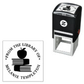 Tampon Auto-encreur Apple sur les livres "De la bibliothèque de" Nom M (En situation)