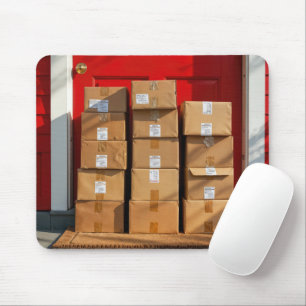 Tapis De Souris Boîtes en carton empilées par une porte rouge