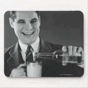 Tapis De Souris Un homme verse de la bière de la bouteille au lanc