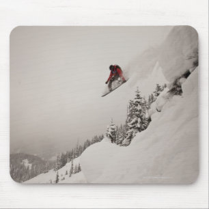 Tapis De Souris Un snowboardeur saute d'une falaise en poudre dans