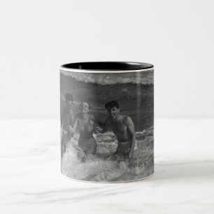 Tasse 2 Couleurs Deux jeunes hommes et femme jouant dans la vague