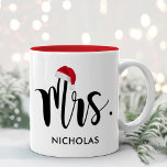 Tasse 2 Couleurs Mme Red Santa Hat sur mesure Monogramme de vacance<br><div class="desc">La tasse de Noël met en vedette Mme dans un script noir moderne avec votre nom de famille personnalisé. Un Santa Rouge festif qui accentue le design. Un cadeau parfait pour un couple nouvellement marié célébrant leur premier Noël de mariage ! Visitez notre magasin pour le Mr. Holiday Mug correspondant....</div>