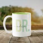 Tasse 2 Couleurs Nouveau Docteur PhD Nom personnalisé Appréciation<br><div class="desc">Cute, tasse à café moderne dire DR dans la typographie moderne dans les tons vert poussiéreux avec votre nom de famille dans la calligraphie script tendance sur une tasse à café deux tons. Un cadeau d'appréciation parfait pour un médecin spécial dans votre vie, un remerciement sincère, ou un cadeau de...</div>