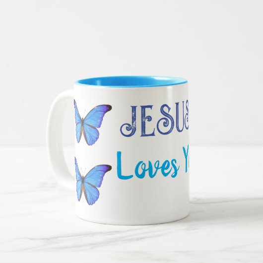 Tasse 2 Couleurs Papillons bleus Jésus vous aime (Devant gauche)