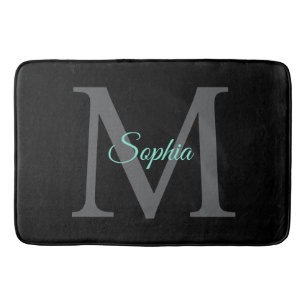 Teal scriptnaam, grote grijze monogram op zwart badmat