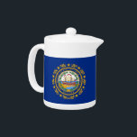 Teapot du drapeau du New Hampshire<br><div class="desc">Servez votre thé avec la fierté de l'État granite à l'aide de notre théière avec le drapeau du New Hampshire! Ajoutez une touche particulière à votre heure du thé avec notre théière élégante ornée du drapeau du New Hampshire. Idéal pour un usage quotidien et des occasions spéciales, cette théière combine...</div>