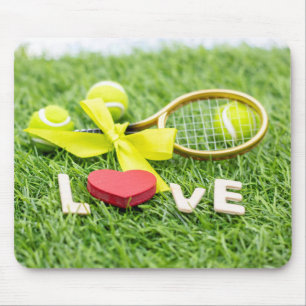 Tennisbal en racket op groen gras met liefde muismat