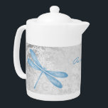 Teote de libellule bleue personnalisée<br><div class="desc">Profitez de votre thé avec une théière personnalisée à la libellule bleue. La conception de la théière comprend une libellule colorée, une vigne feuillue blanche molle contre un arrière - plan damassé gris clair avec une zone à personnaliser avec votre nom. Autres cadeaux disponibles avec ce design ainsi qu'une variété...</div>