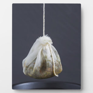 Thee zakje hangt in een kop fotoplaat