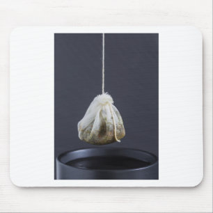 Theezakje hangt in een kop muismat