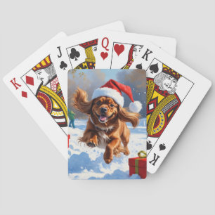 Tibetaanse Spaniel loopt in de sneeuw met kerstmut Pokerkaarten