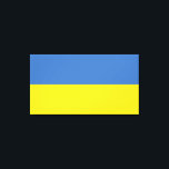 Toile Drapeau ukrainien Slava Ukraini С л а в а р У к d<br><div class="desc">Les couleurs du drapeau ukrainien, bleu et jaune, flottent depuis des siècles sur une terre riche d'histoire et d'esprit. Le bleu représente le vaste ciel ukrainien, tandis que le jaune symbolise les champs de blé doré qui s'étendent à travers ses plaines fertiles. Ce symbole simple mais puissant est devenu un...</div>