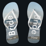 Tongs Bride Ocean Waves Beach Sand<br><div class="desc">Joli Ciel Bleu avec des nuages Blancs clairs, Mer Bleue, Vagues d'Océan et Sable de Plage. Unisex Flip Flops with Bride and Date of Marriage écrit dans un texte blanc. PERSONNALISER avec votre DATE Mariage (ou supprimer du texte). La date du mariage est écrite dans le sable. Choisissez des sangles...</div>