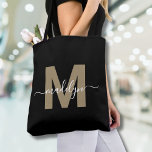 Tote Bag Black Gold tendance moderne Nom de script Monogram<br><div class="desc">Personnalisé Elégant Black Gold tendance moderne nom de script Monogram Sac fourre-tout. Ajoutez une touche de glamour et de sophistication à votre style quotidien avec ce sac fourre-tout chic. Doté d'une initiale en or fin (note : l'or est une couleur plate, sans éclat ni feuille) centrée sur un arrière -...</div>