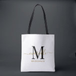 Tote Bag Bridesmaid Cadeau Or Noir Monogramme Blanc<br><div class="desc">Ce sac fourre-tout de Bridesmaid présente un monogramme manuscrit de typographie en or et en écriture noire avec des swashes sur un arrière - plan blanc. Présentez vos serveuses d'honneur avec un fourre-tout pour transporter des objets le jour du mariage,  et traditionnellement présentés au dîner de répétition ou avant.</div>