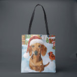 Tote Bag Dachshund Winter Wonderland Christmas Joy<br><div class="desc">Ce design festif reflète l'esprit joyeux de la période des fêtes, avec un adorable petit portant un chapeau de Père Noël. Le chien est niché dans un pays des merveilles hivernales, avec un bonhomme de neige, un sapin de Noël décoré et des cadeaux joliment emballés. Les flocons de neige tombent...</div>