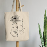 Tote Bag Élégant nom de script Lotus Juillet Mois de naissa<br><div class="desc">Elégante, minimaliste et moderne, fleur de lys ou de lotus d'eau dessinée à la main noire, fleur de mois de naissance de juillet avec nom personnalisable dans un script élégant, cadeau personnalisé pour toute occasion, y compris les anniversaires, cadeaux pour les demoiselles d'honneur, les meilleurs amis, Noël, et plus encore....</div>