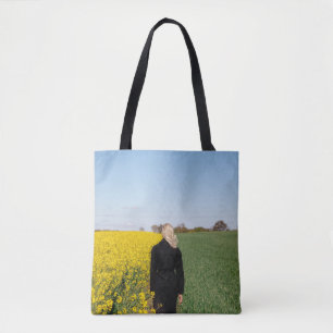 Tote Bag Femme en manteau noir debout sur un terrain d'herb