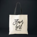 Tote Bag Fille Fleur Lettrée Main Noire Personnalisée<br><div class="desc">Sac fourre-tout de fille de fleurs personnalisable. Sac fourre-tout moderne et classique avec écriture manuscrite noire "fleurie fille". Personnalisez en ajoutant le nom du destinataire,  le hashtag du mariage ou d'autres détails. Parfait comme cadeau pour votre fête de mariage ou de mariage.</div>