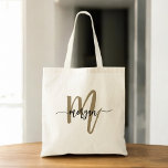 Tote Bag Nom du monogramme Black Gold Modern Script<br><div class="desc">Portez vos articles de première nécessité dans le style avec le Sac fourre-tout de nom Monogramme moderne noir et or. Doté d'une toile noire épurée avec un monogramme d'or audacieux dans une police de script moderne, ce sac fourre-tout allie élégance et fonctionnalité. Assez spacieux pour le shopping, le travail ou...</div>