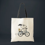 Tote Bag Peanuts | Snoopy & Woodstock Bicycle<br><div class="desc">Pedal into style and classic charm with this adorable cream canvas tote bag, featuring Snoopy and Woodstock on a bicycle! This fun tote showcases a delightful line-art illustration of Snoopy, wearing sunglasses, happily riding a vintage-style blue bicycle with Woodstock perched safely behind him. The dashed lines behind the back wheel...</div>