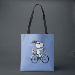 Tote Bag Peanuts | Snoopy & Woodstock Bicycle<br><div class="desc">Pedal into style and classic charm with this adorable cream canvas tote bag, featuring Snoopy and Woodstock on a bicycle! This fun tote showcases a delightful line-art illustration of Snoopy, wearing sunglasses, happily riding a vintage-style blue bicycle with Woodstock perched safely behind him. The dashed lines behind the back wheel...</div>