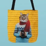 Tote Bag Photographe de chat en Vintage Sweater Quirky<br><div class="desc">Fourre-tout vos affaires en style avec l'aide de ce chaton mignon et décalé. Ce sac fourre-tout présente un montage photo illustrant un chat habillé d'un pull de style rétro et tenant une caméra vintage. Le tabby dans son écharpe rouge et son pull bleu est placé contre un mur de brique...</div>
