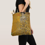 Tote Bag Portrait d'Adele Bloch-Bauer I par Gustav Klimt<br><div class="desc">Portrait d'Adele Bloch-Bauer I (1903-1907) par Gustav Klimt est un vintage portrait de l'époque victorienne Symbolisme d'art. Portrait d'Adele Bloch-Bauer I est aussi connu comme La Dame en Or ou la Femme en Or. Le portrait montre Adele Bloch-Bauer assis sur une chaise dorée devant un arrière - plan étoilé doré....</div>