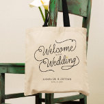 Tote Bag Script moderne Gold Bienvenue à notre Faveur de ma<br><div class="desc">Ce sac fourre-tout moderne avec un design de calligraphie décontracté et chic minimaliste lecture BIENVENUE À NOTRE MARIAGE ainsi que vos noms personnalisés et la date des nuptiaux dispose de lignes propres pour créer un aspect élégant et sophistiqué. Le style sobre et le petit détail imprimé du coeur d'or ajoutent...</div>