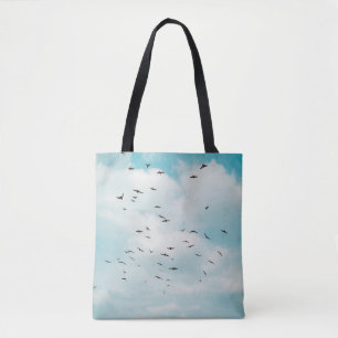 Tote Bag Un troupeau de colombes grises vole sur le ciel bl