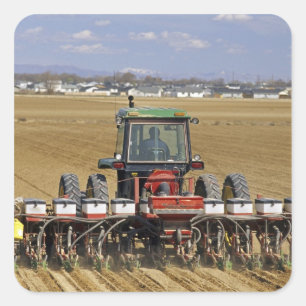 Tractor die een maiszaaimachine trekt. vierkante sticker