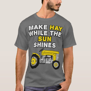Tractor maakt hooi terwijl de zon de zomer van de t-shirt