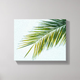Tropisch groene palmblad op lichtblauw canvas afdruk
