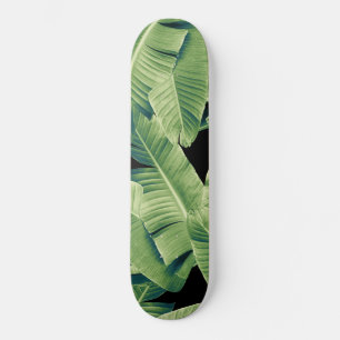 Tropische bananenbladeren verlaten het nachtelijke skateboard