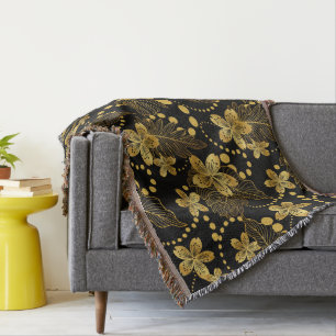 tropische bladeren en bloemen in goud op zwart deken