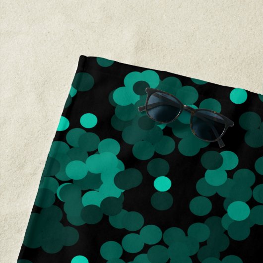 Turquoise groen polka dot patroon op zwart strandlaken (In situ)