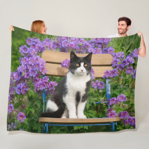 Tuxedo-kat op een tuinstoel met bloemen fleece deken