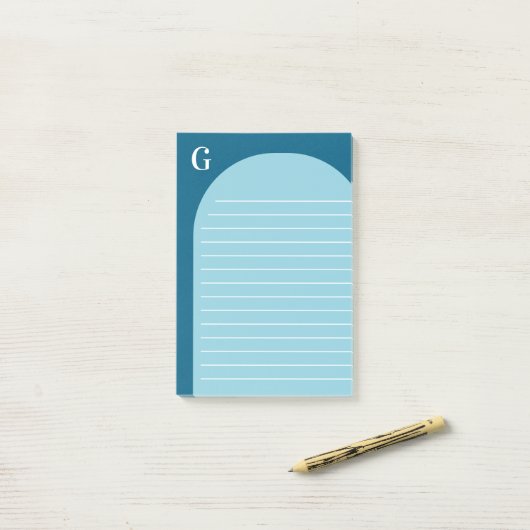 Twee tinten blauw gevoerd boog monogram post-it® notes (Op bureau)