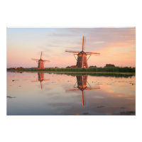 Twee windmolens met reflectie bij zonsondergang