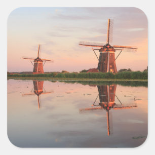 Twee windmolens met reflectie bij zonsondergang vierkante sticker