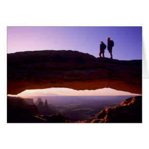 Un couple observe le lever du soleil depuis le som