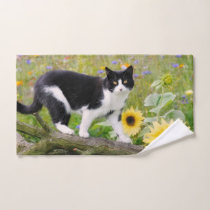 Un mignon chat tuxedo sur une branche d'arbre avec