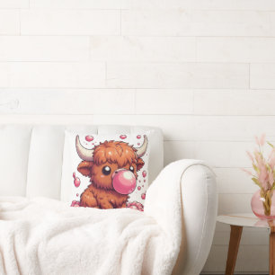 veau de vache des Highlands soufflant un coussin d