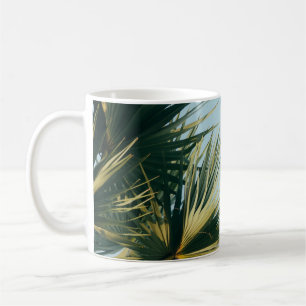 Ventilatorpalm onder blauwe hemel koffiemok