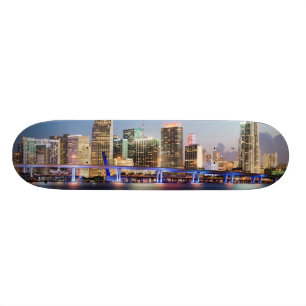 Verlichtde skyline van het centrum van Miami bij s Skateboard