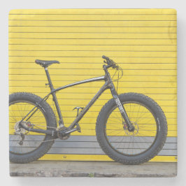 Vetfiets op gele wand stenen onderzetter