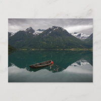 Vieux bateau à rames avec carte postale de montagn